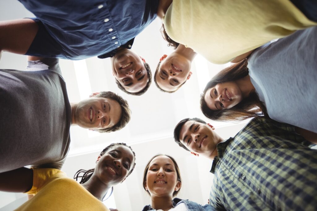 Group Of Business Executives Forming Huddle