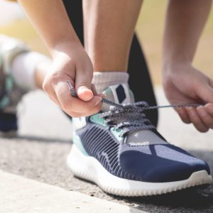 Tu bienestar - Salud - Imagen para artículo de hábitos saludables: corredor atándose los zapatos